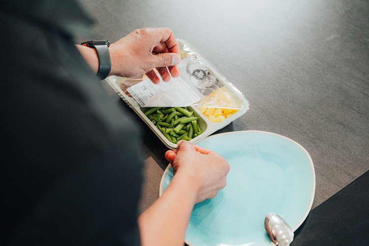 Een maaltijd verpakking wordt opengemaakt