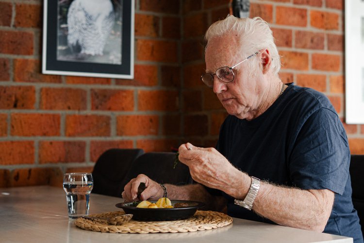 Klant zit aan tafel en eet een maaltijd