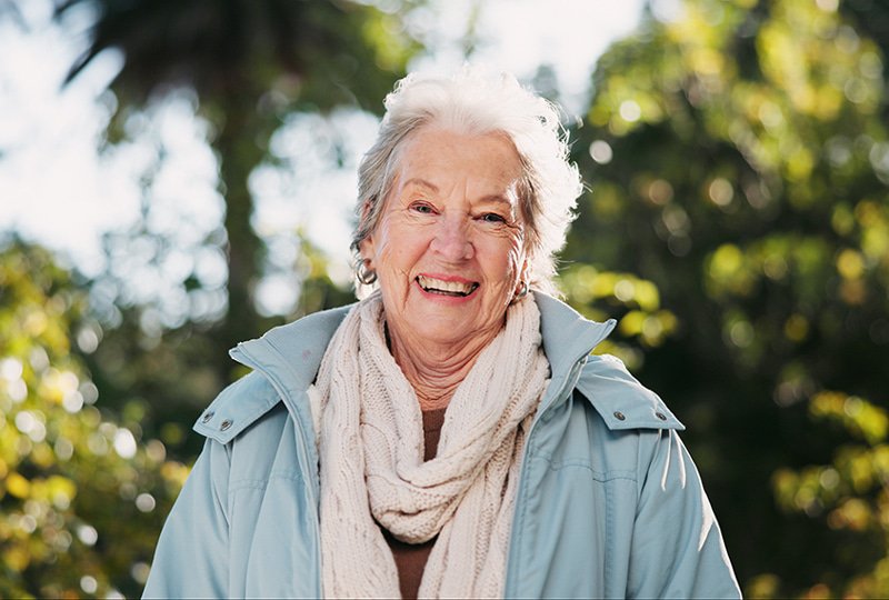 Een klant staat in het bos en lacht in de camera