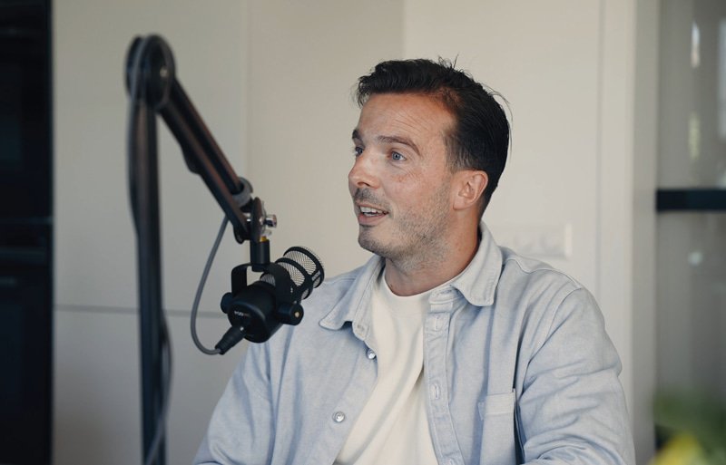 Joost de Man zit achter een microfoon