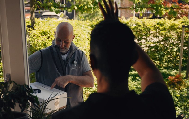 Duco Bauwens zwaait door het raam naar de bezorger van Vers aan Tafel