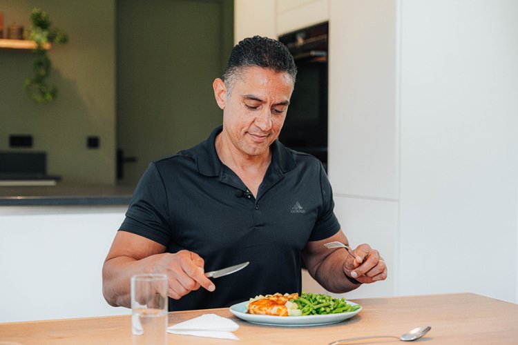 Duco Bauwens zit aan tafel met een maaltijd voor zich